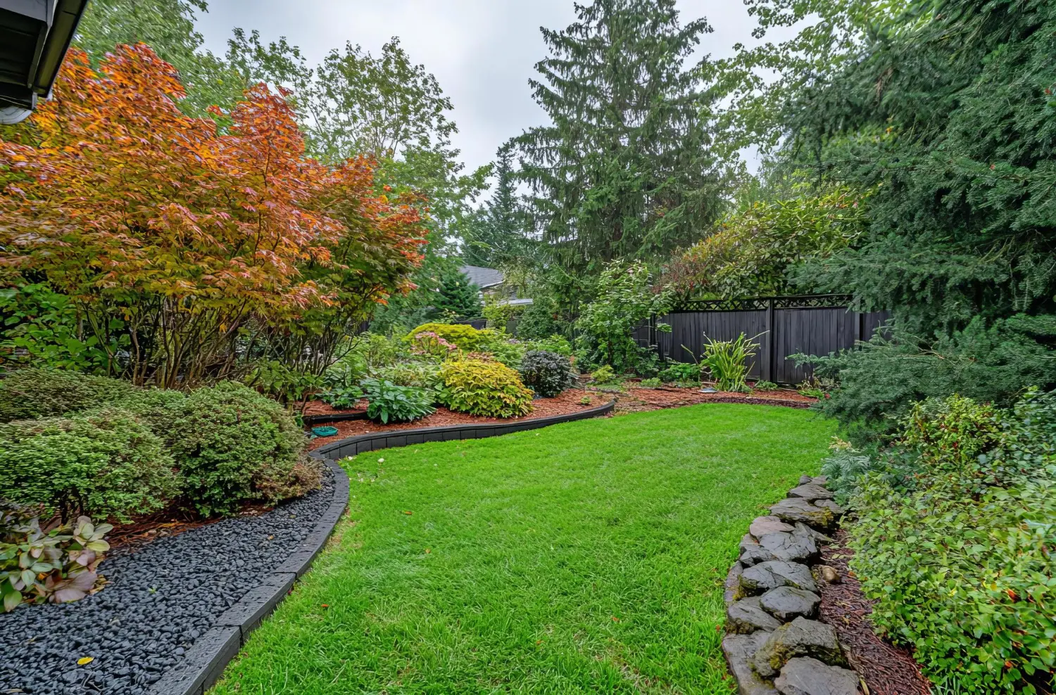 Professionally maintained residential landscape with layered planting and a manicured lawn